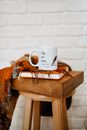 Mug Standing on Copybook, Box and Shawl Laying on Wooden Stool