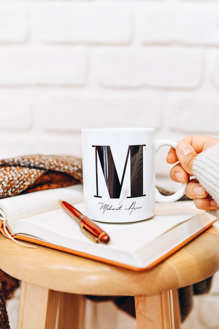 Unrecognizable Female Hand Holding White Mug By Handle