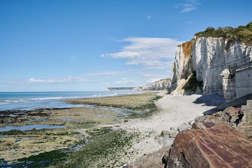 A Rocky Mountain Near the Beach Under the Blue Sky and White Clouds