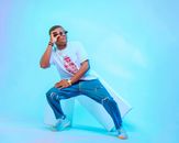 Fashionable young man in casual attire posing confidently in a studio.
