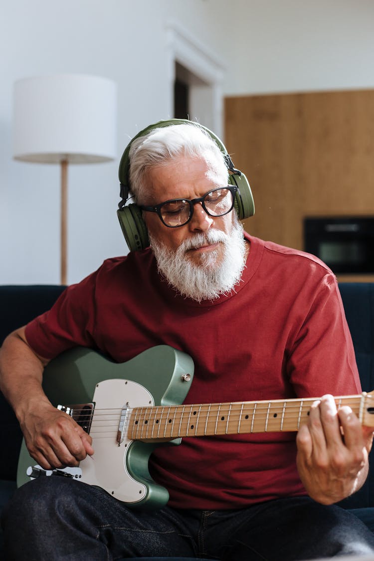 Elderly Man Playing On Electric Guitar