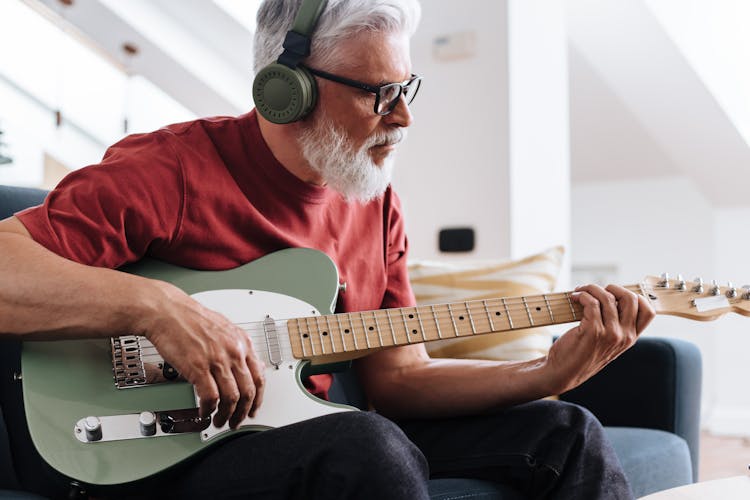 Elderly Man Playing On Electric Guitar