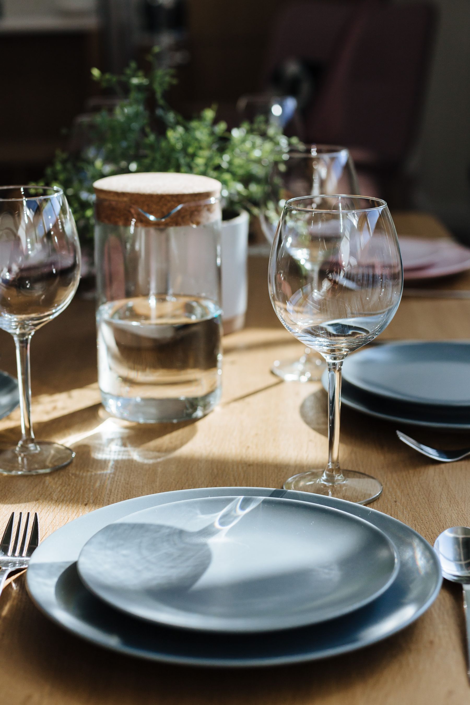 Refined dining table with plates, cutlery, glasses and serving pieces