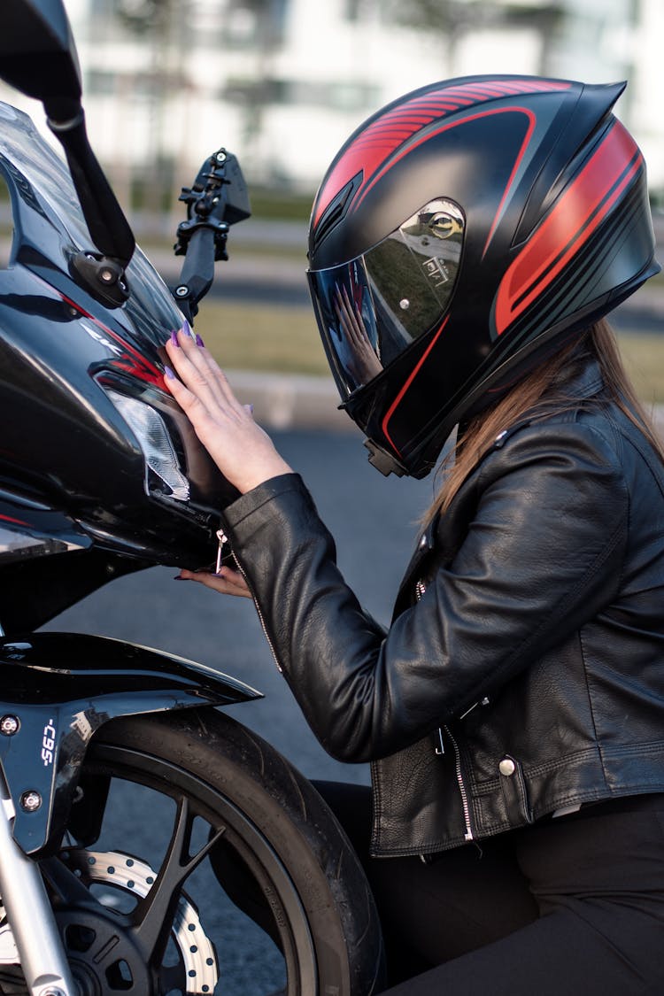 Rider Wearing Helmet Holding A Motorcycle