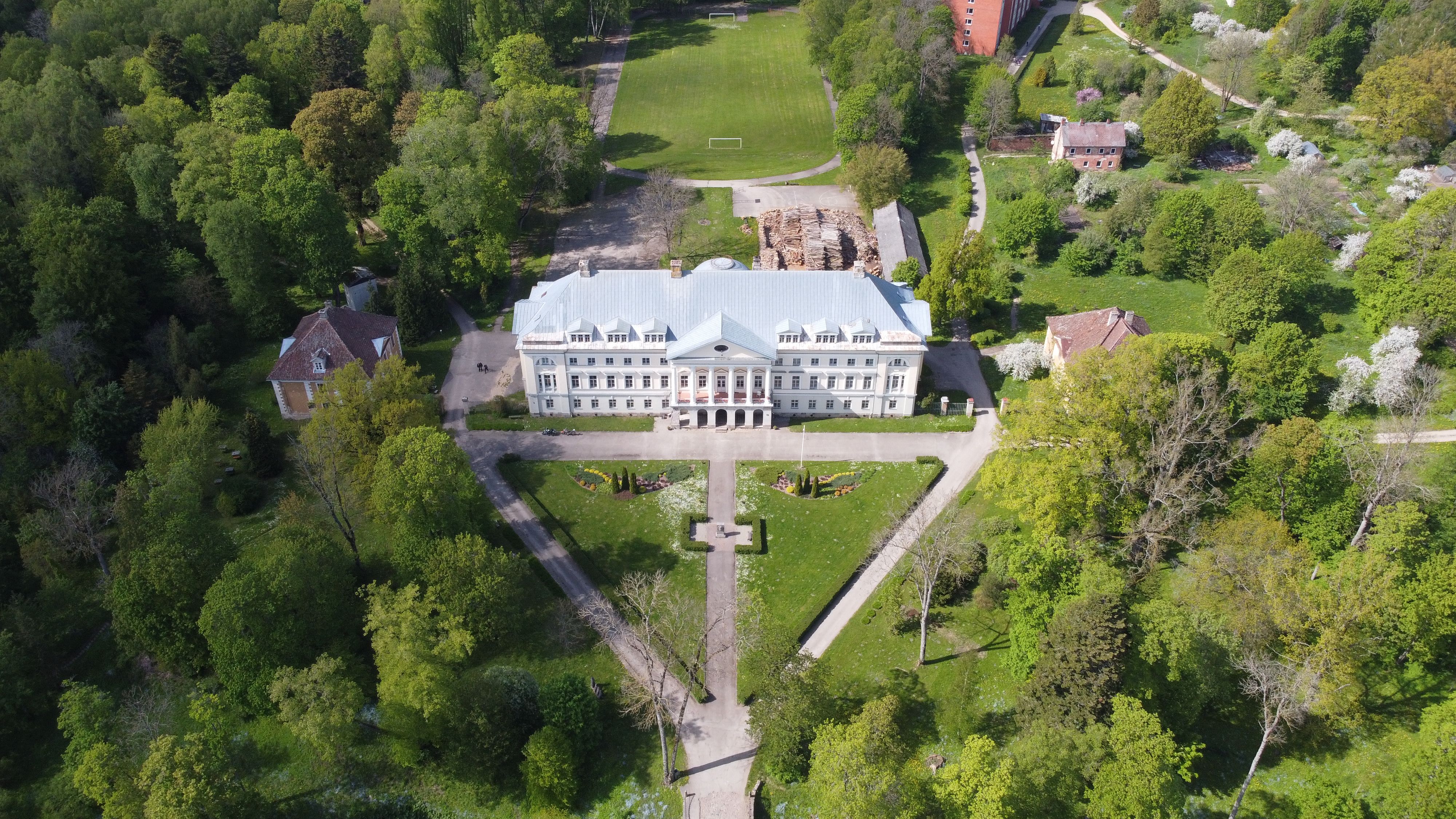 Aerial view of a historic manor in lush green surroundings, Kazdanga, Latvia.