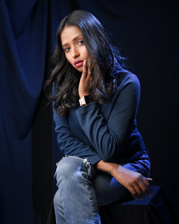 Woman In Sweatshirt Posing With Hand On Cheek