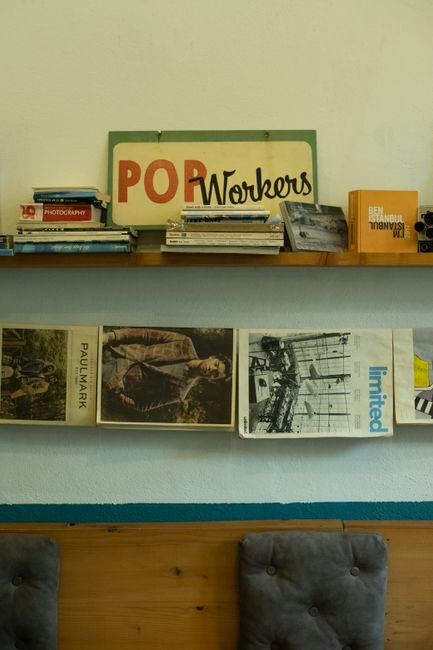 Stylish vintage-themed shelf with books, magazines, and retro decor in a cozy interior setting.