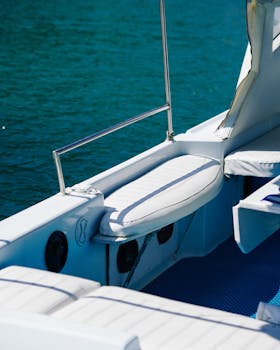 Close-up of a yacht's deck with seating and a clear view of the water on a sunny day.