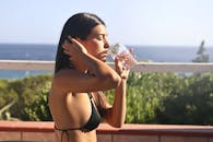 一位穿着泳装的女人在美丽的海景中享受着清凉的饮料