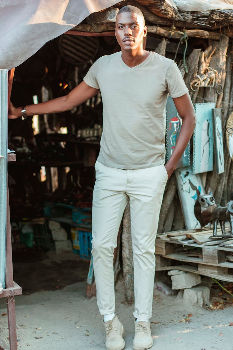 Man In Gray Shirt And Khaki Pants Standing While Looking At The Camera