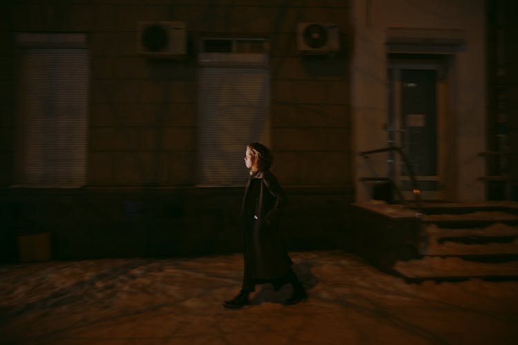 Side View Of Woman Walking Alone At Night