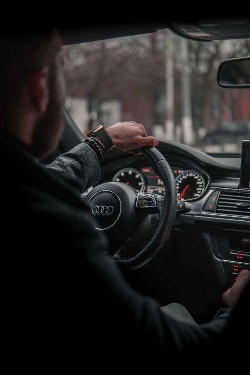 Free Man driving a luxury car in Moscow, showcasing a sleek interior with focus on steering wheel and controls. Stock Photo