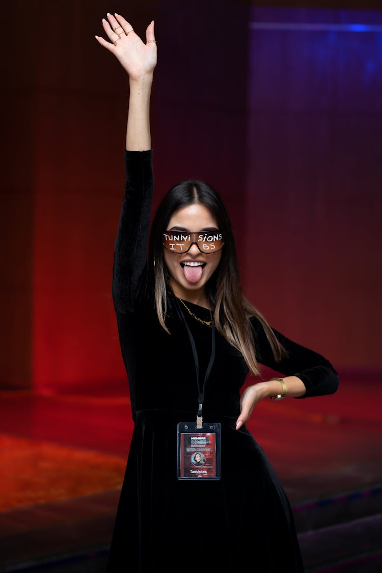 Woman In Black Dress Sticking Her Tongue Out