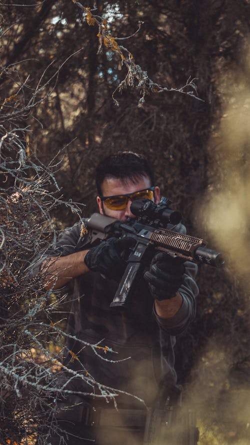 Free A Man in Military Uniform Holding Black Rifle Stock Photo