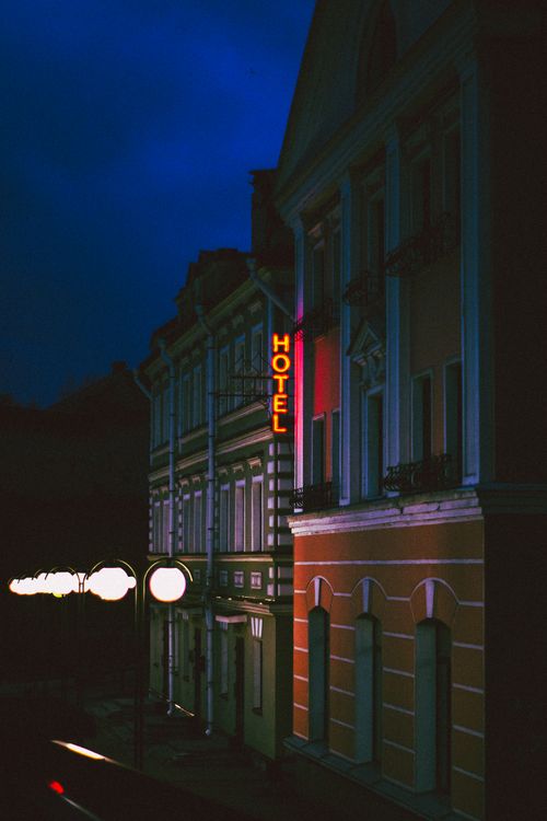 Free Night view of a hotel with neon signage in an urban street, showcasing architectural details. Stock Photo