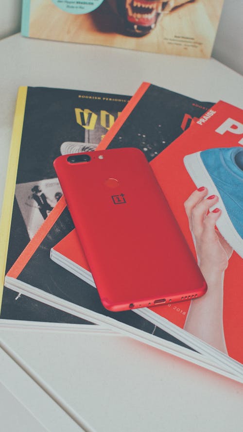 Red Oneplus Smartphone on Books