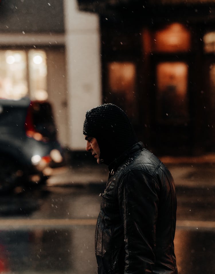 Man In Hoodie And Black Leather Jacket Walking In The Rain