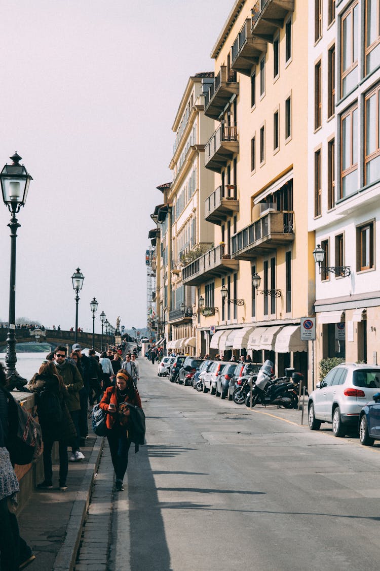 People Walking Along Pavement Near Building