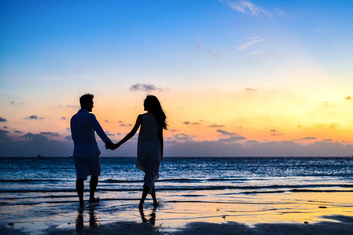 Man En Vrouw Hand In Hand Lopen Op Kust Tijdens Zonsopgang