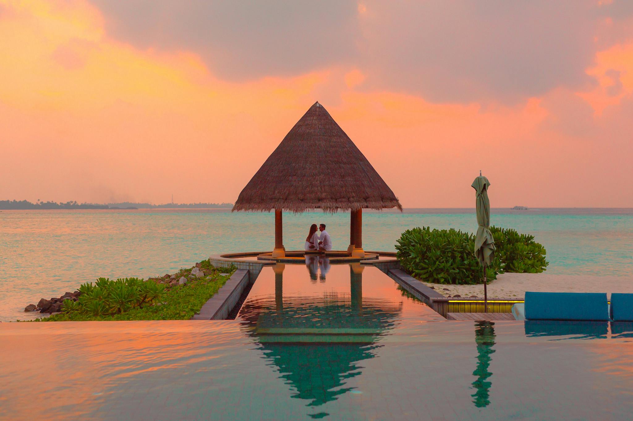 Couple Under Hut Beside Sea And Infinity Pool Free Stock Photo