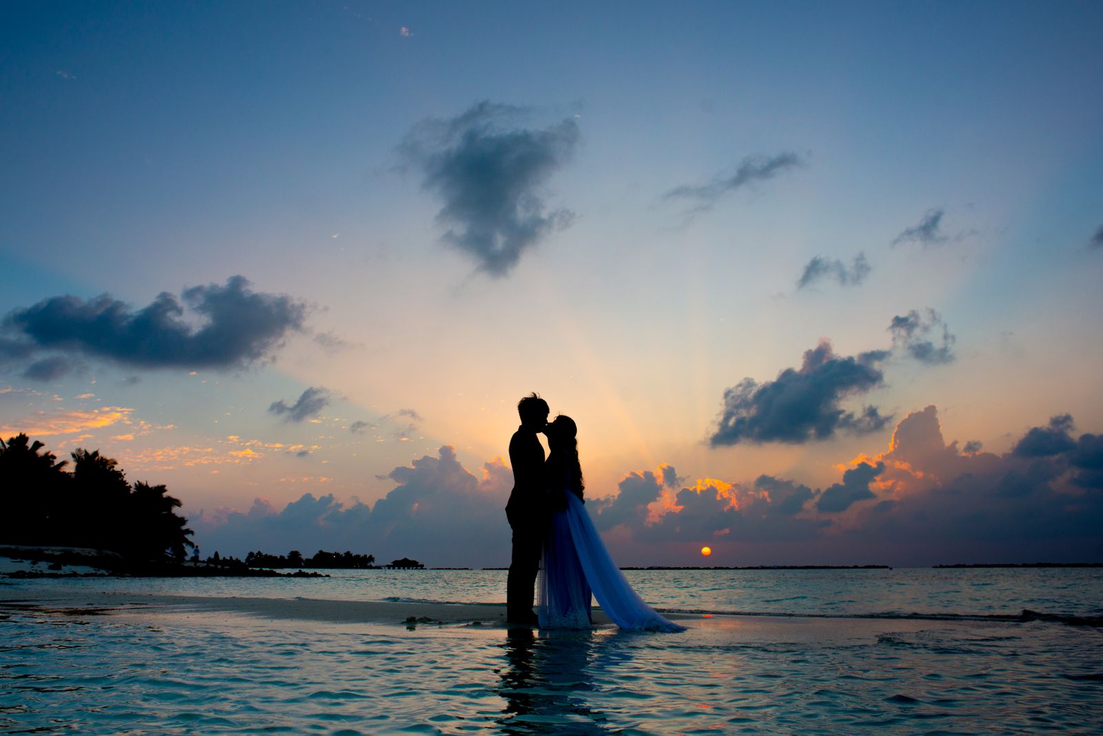 Romantic couple on tropical beach at sunset