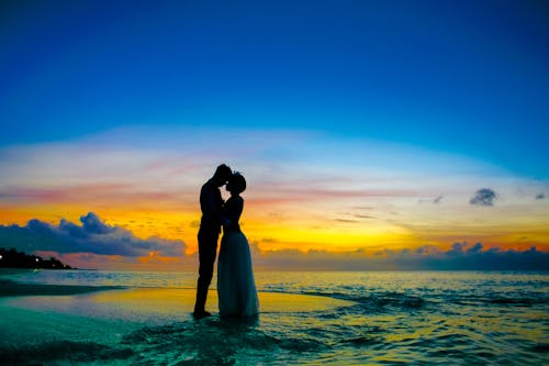 Free Man and Woman Standing at Seashore Stock Photo