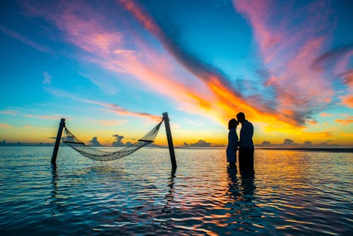 免费 剪影照片夫妇在日落期间互相亲吻 素材图片