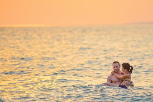 Free Man and Woman Swimming in a Beach Stock Photo