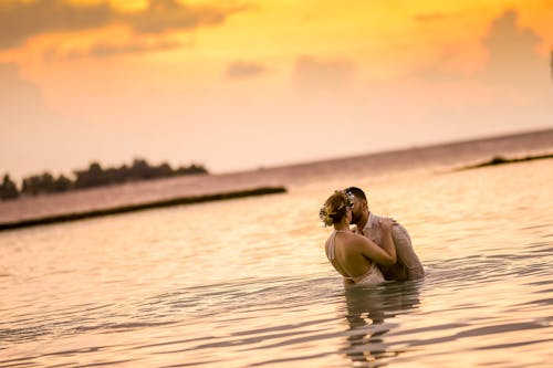 Free Woman and Man Kissing in Body of Water Stock Photo