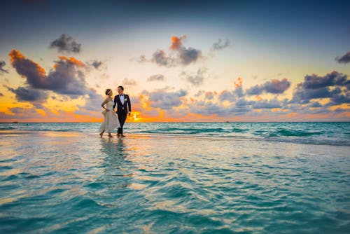 Free Man and Woman Walking of Body of Water Stock Photo