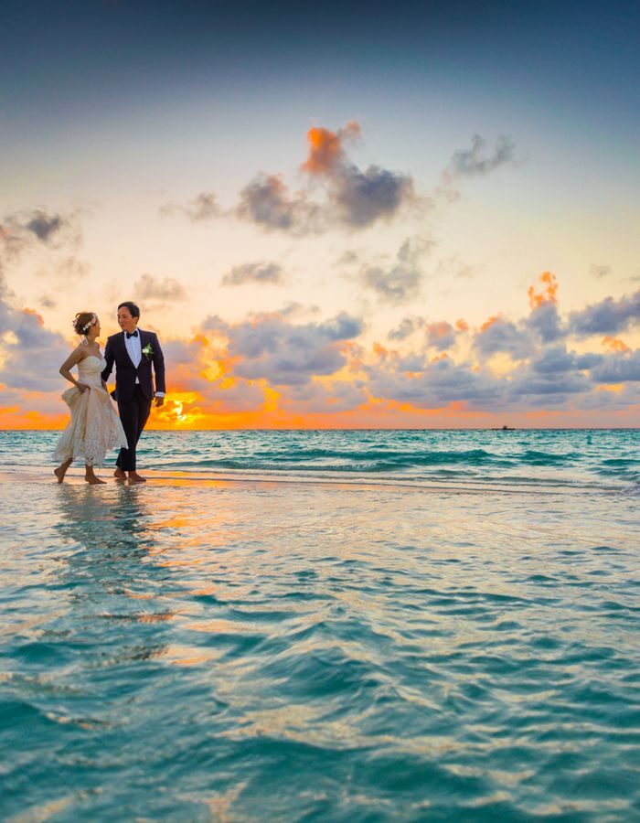 Casal de noivos ao pôr do sol na praia