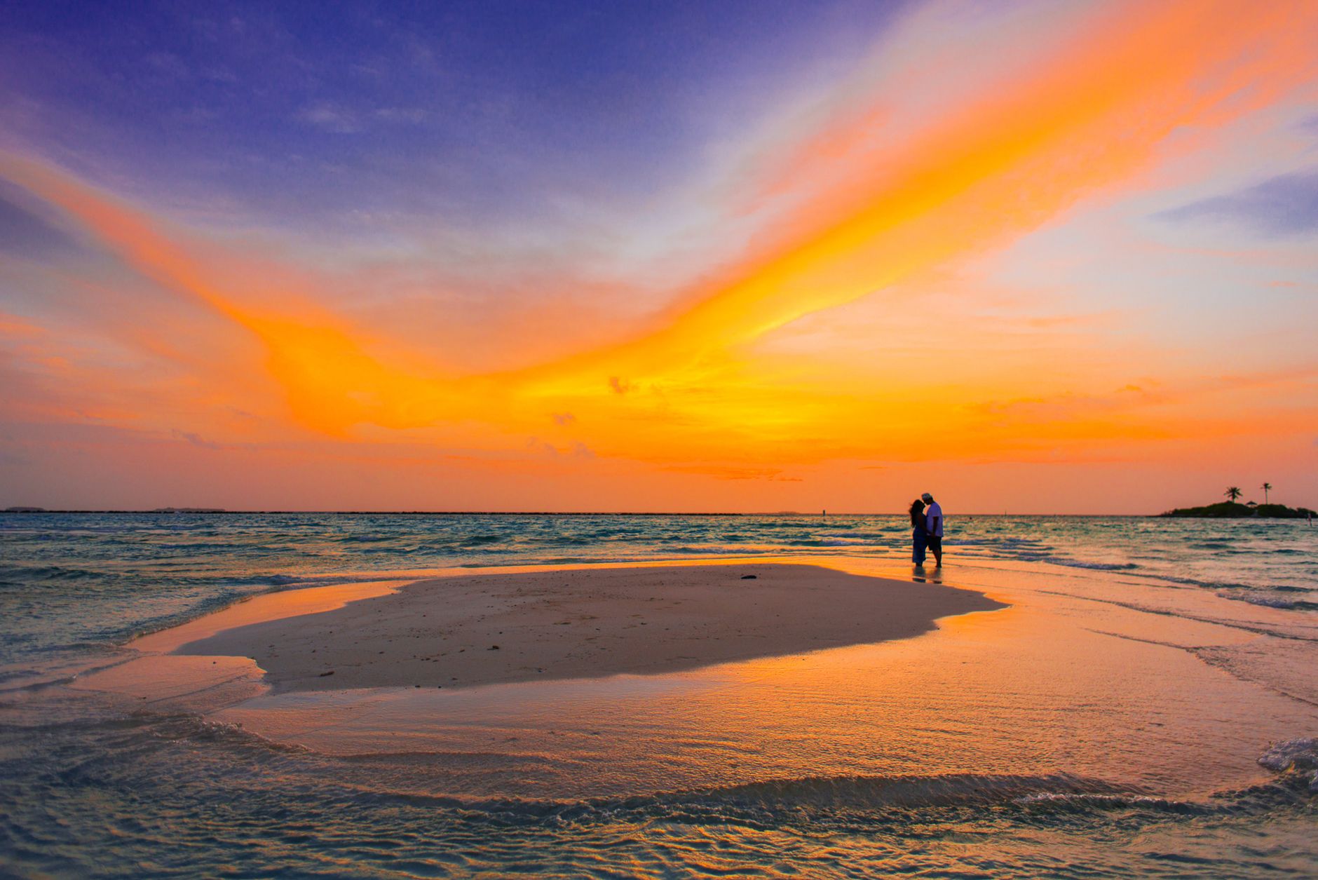 Pareja en la playa al atardecer durante su luna de miel