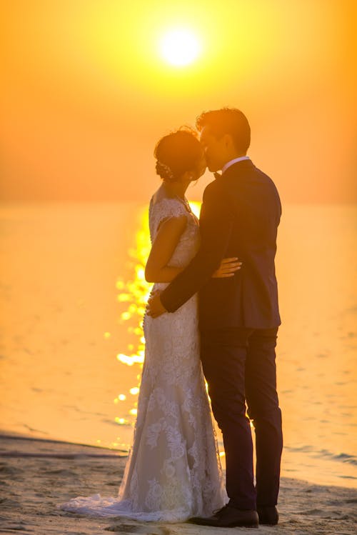 Free Man and Woman Kissing Under Sunset Stock Photo