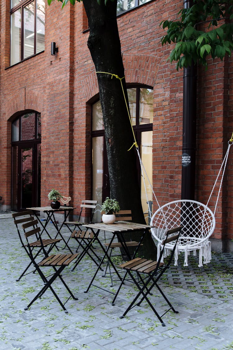 Tables Chairs And Swing Chair At Outdoor Cafe