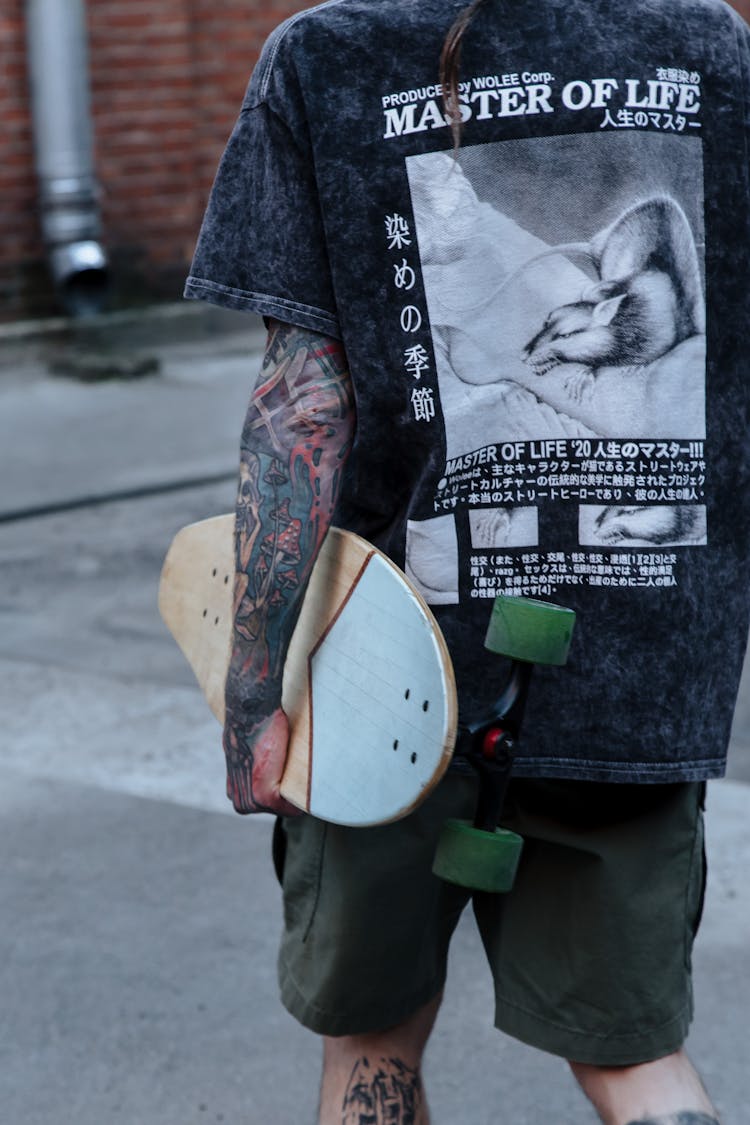  Unrecognizable Skateboarder Wearing T-shirt And Shorts Holding Skateboard