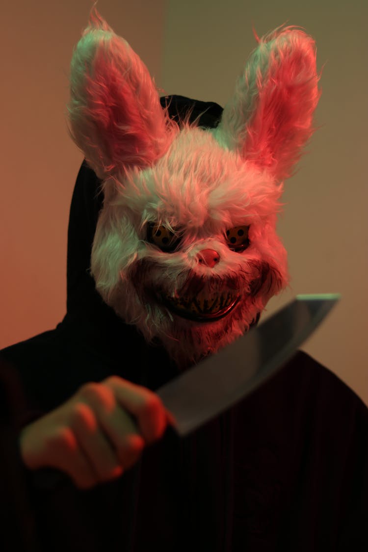 A Person Wearing A Scary Rabbit Mask Holding A Knife