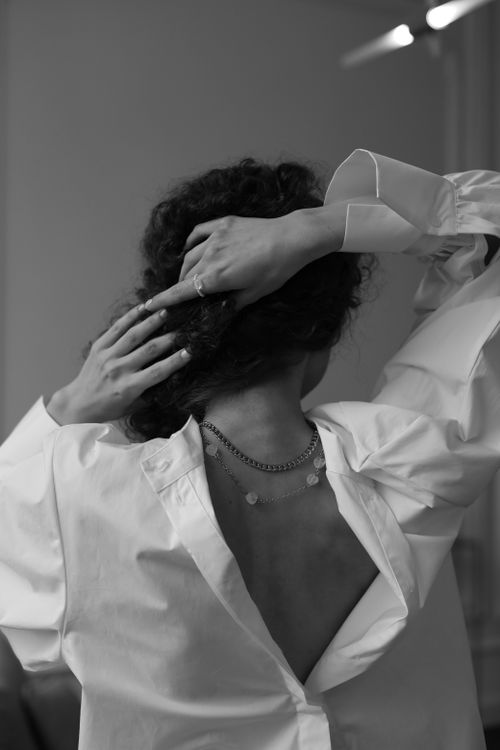 Free Elegantly posed woman in white shirt captured in monochrome, highlighting minimalistic style. Stock Photo