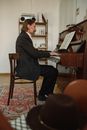Elderly Man in Black Suit Playing the Piano