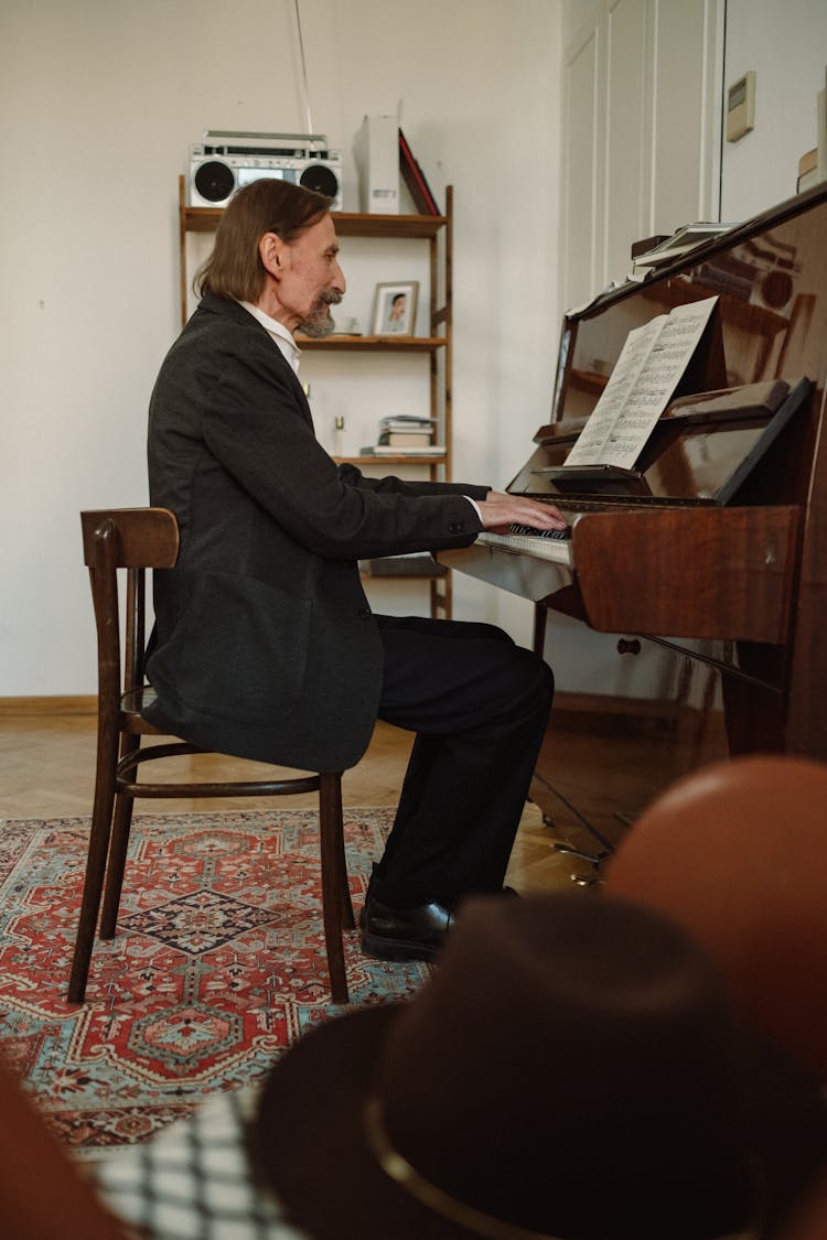 Elderly Man In Black Suit Playing The Piano