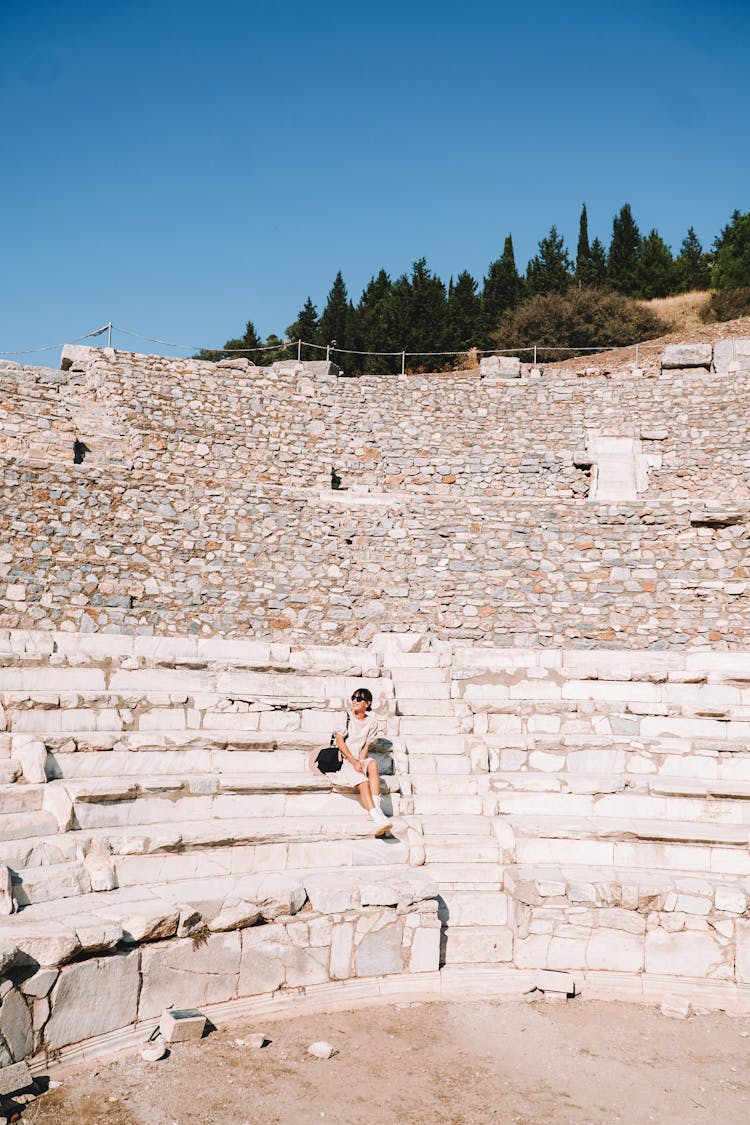 Woman Sitting On The Steps In An Amphitheater 