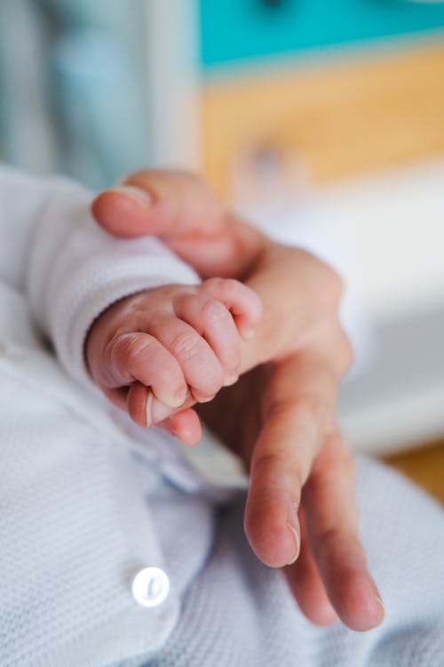 A Baby Holding a Finger