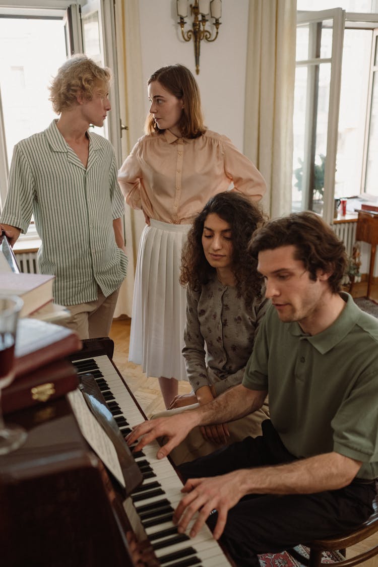 People Watching A Man Playing The Piano Indoors 