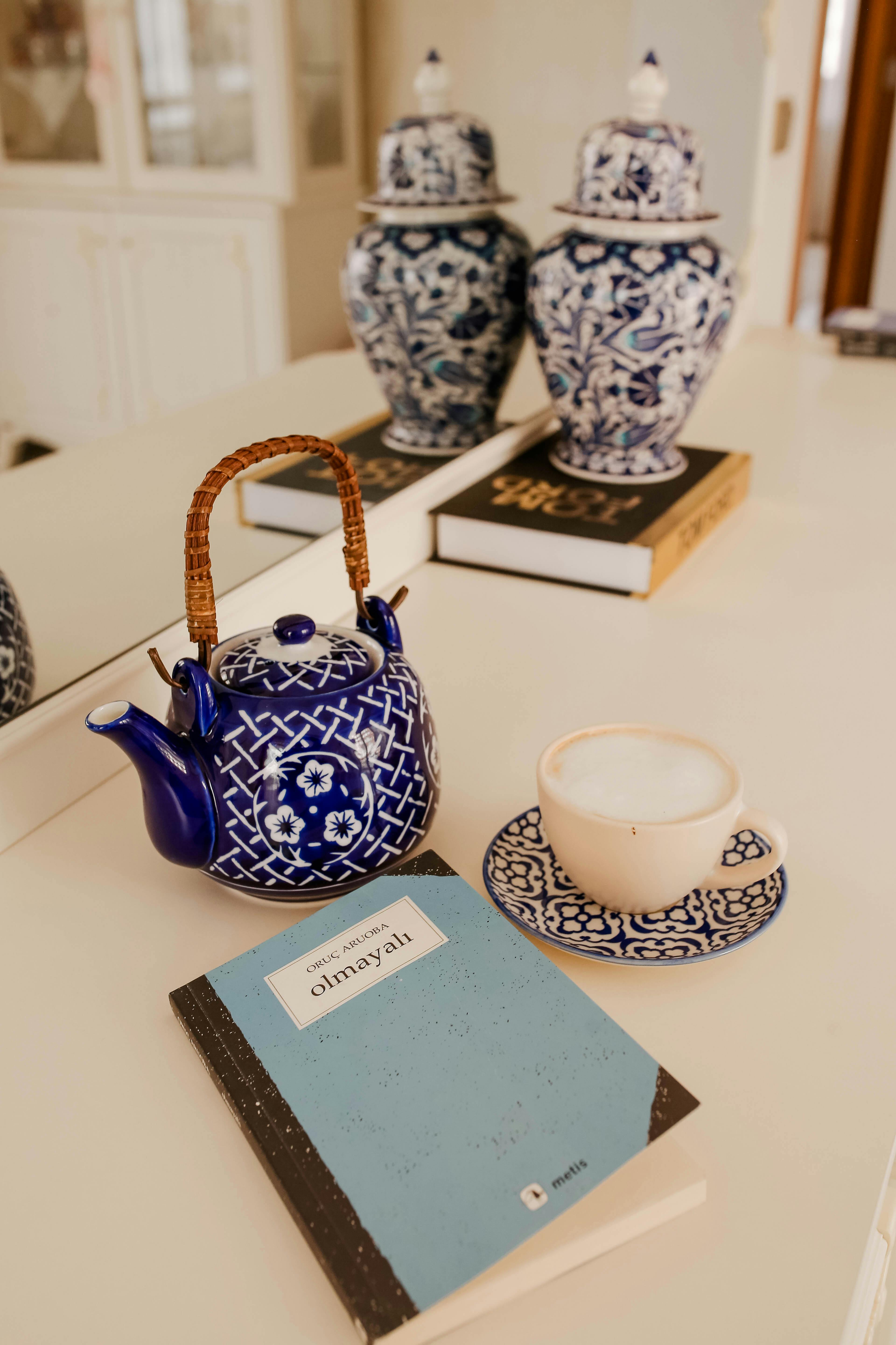 Stylish blue and white ceramics with a tea set and books on a dresser, adding an artistic touch.