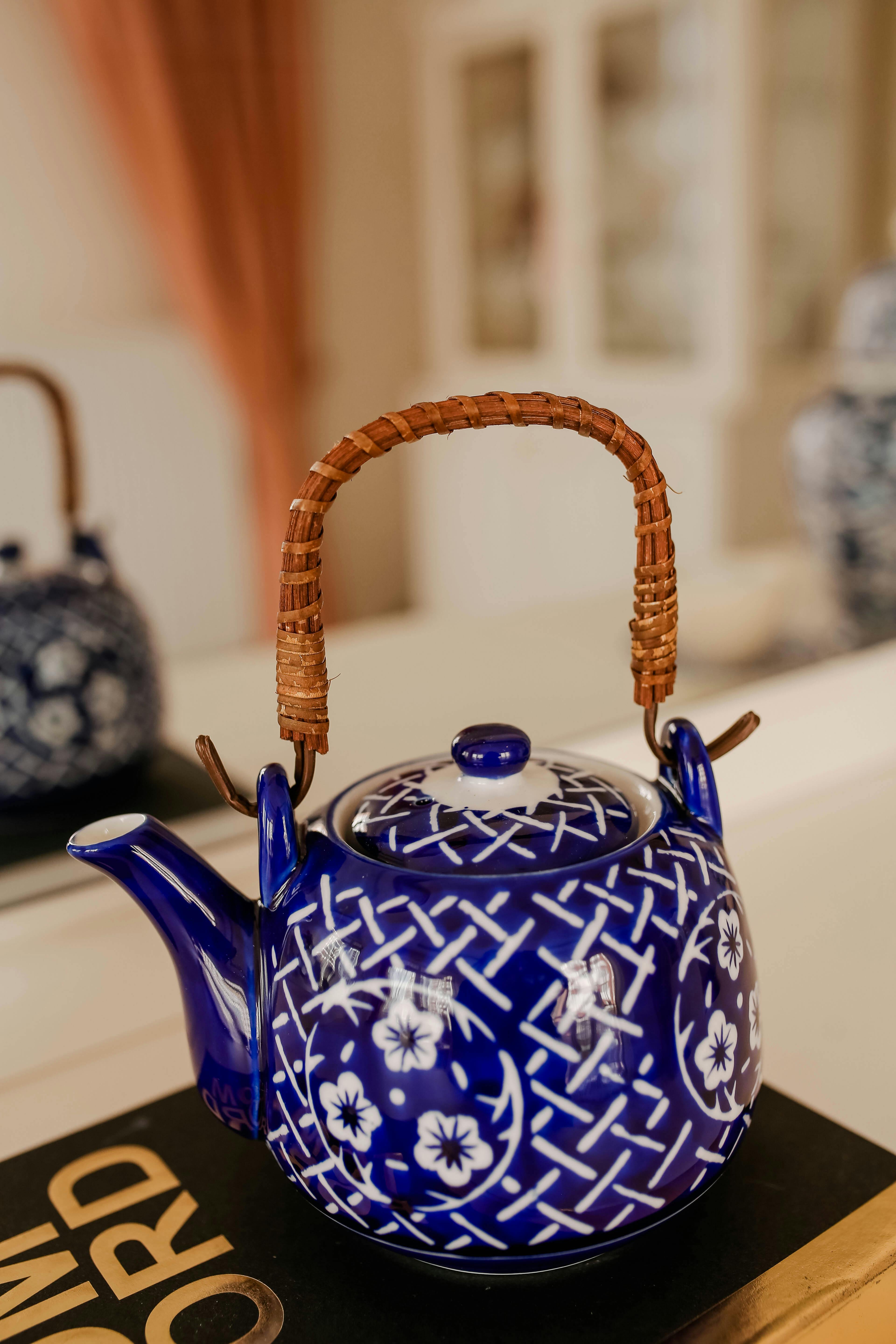 Close-up of a blue porcelain teapot with floral patterns, showcasing elegant design and craftsmanship.