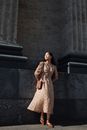 Woman Standing in front of a Building in the Sun