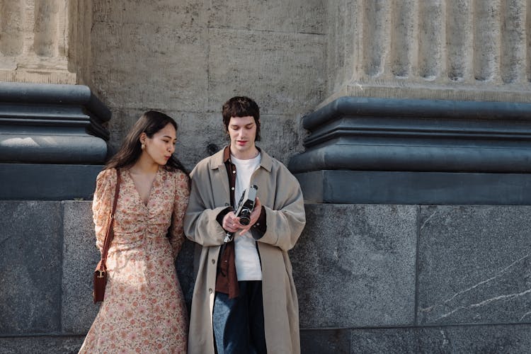 Man And Woman Looking At Analog Camera