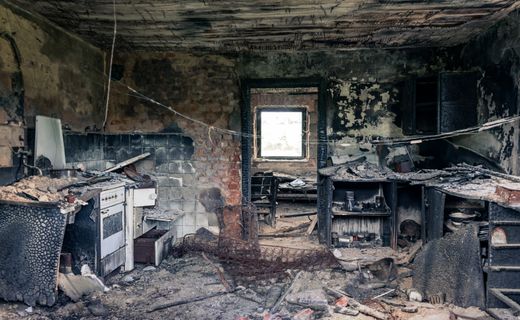 Fire-damaged kitchen with smoke marks on the walls
