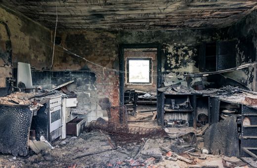 Fire-damaged kitchen with smoke marks on the walls