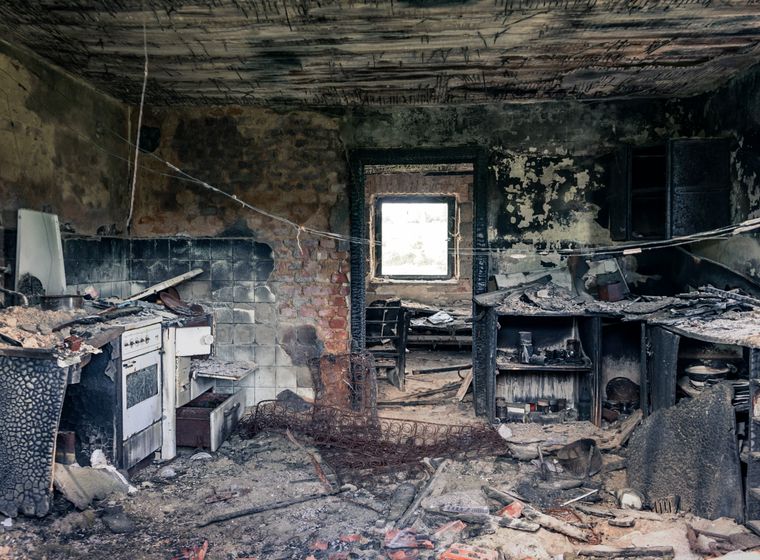 Fire-damaged kitchen with smoke marks on the walls