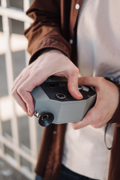 Free Close-up of hands holding a vintage analog camera outdoors, capturing a moment. Stock Photo